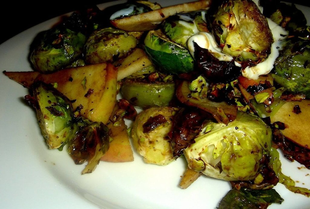 Charred Brussels sprouts, sweet apples, sour crème fraîche and toasted pistachios combine to form a delicious mixture of contrasting flavors and textures in this 烧焦的球芽甘蓝、甜苹果、酸crème fraîche和烤开心果结合在一起,形成了一种对比鲜明的口味和质地的美味混合在这个“Alta”tapas娱乐。减少了香醋的味道,让人立刻感到香甜和尖锐。/ / www.simonrockett.com