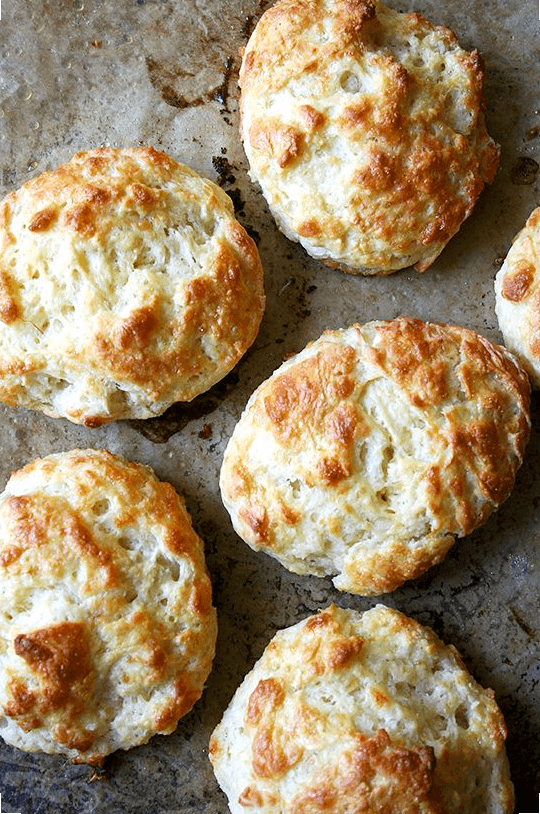 Tender and flaky, these buttermilk cheddar biscuits are the perfect vessel for housing slices of ham or turkey or roast beef, handfuls of arugula, and a slathering of mustard sauce, a must-have recipe if you're making ham this holiday season. // www.simonrockett.com 这些酥脆的酪乳切达饼干是放置火腿片、火鸡片或烤牛肉片、一把芝麻菜和一层厚厚的芥末酱的完美容器,如果你在这个假期做火腿,这是必不可少的食谱。/ / www.simonrockett.com