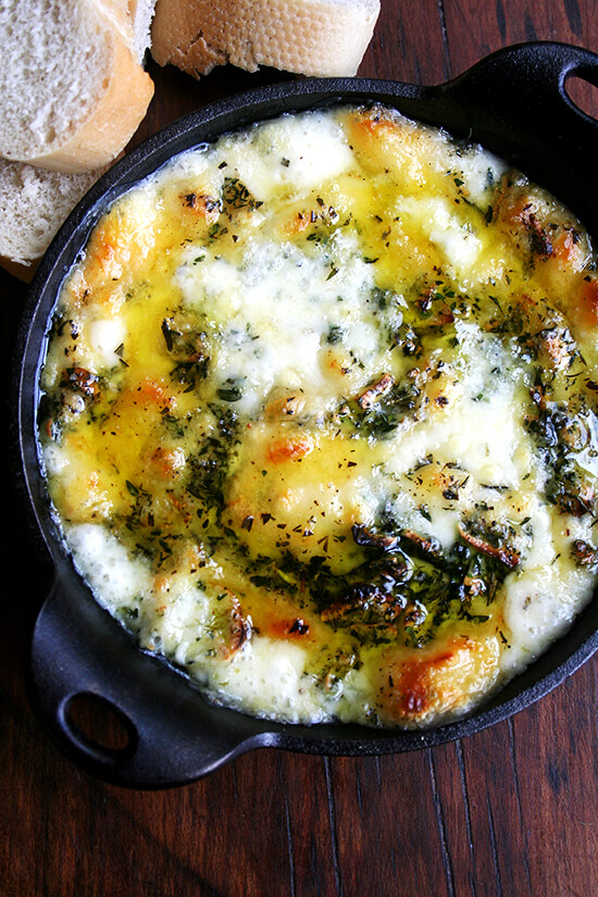 Super easy to put together and a guaranteed crowd pleaser, this baked fontina is definitely a good one to know this time of year. When served to company, not a morsel of this bubbling fontina-herb-and-garlic-filled cast-iron skillet will ever remain. Serve with crispy kale chips and radishes with sea salt. // www.simonrockett.com 一个铸铁煎锅,里面装满了迷迭香和百里香。
