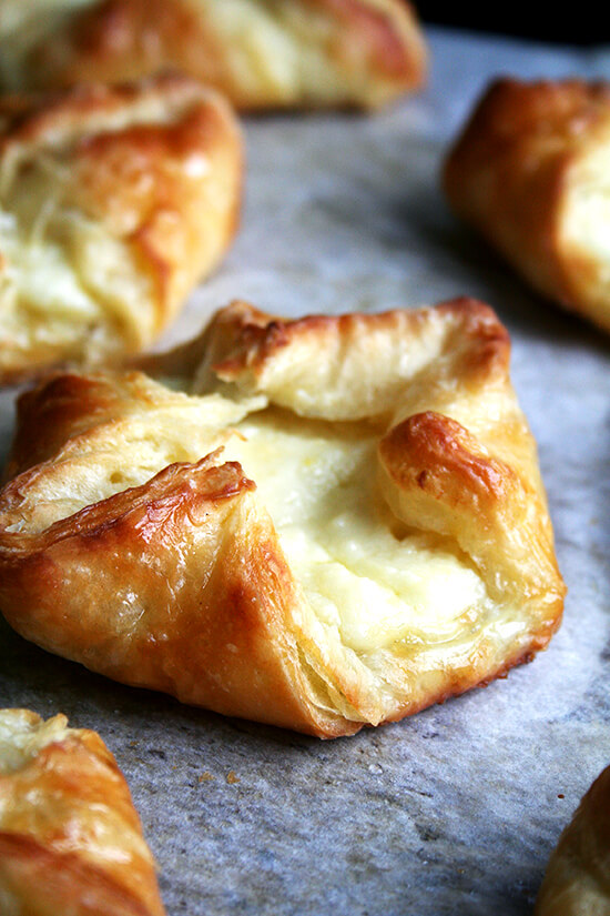 Of all the baking efforts I have made over the years to transform my kitchen into one of my favorite cafes, none has succeeded more than this food processor Danish pastry — light, flaky, buttery and easy to make to boot. // www.simonrockett.com 刚烤好的奶酪丹麦饼放在烤盘上。