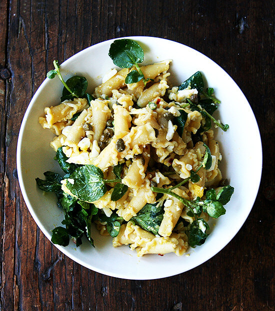 In this campanelle dish, a warm anchovy-caper-olive oil sauce dresses the pasta first; then a splash of lemon juice and reserved cooking liquid thin out the sauce ensuring it coats the pasta nicely; finally chopped hard-boiled eggs and greens complete the dish to make an impromptu, deeply satisfying dinner. // www.simonrockett.com 在这道菜中,温凤尾鱼-刺山柑-橄榄油酱首先浇在意大利面上;然后淋上一点柠檬汁和备用的烹饪液,使酱汁变稀,确保它能很好地覆盖在意大利面上;最后,剁碎的煮熟的鸡蛋和绿色蔬菜就完成了这道菜,这是一顿即兴的、令人非常满意的晚餐。/ / www.simonrockett.com