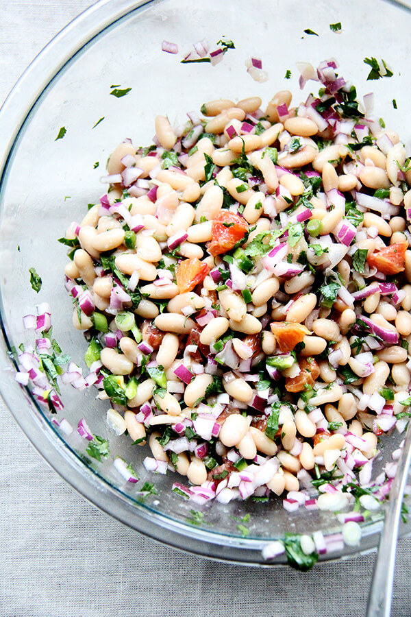 We've been eating this white bean and orange salsa, mixed with onions, lime, jalapeños, cilantro, and orange, with chips, but it would be nice tucked inside a taco or a burrito or aside spicy wings and nachos and anything else you might find yourself surrounded by on game day. // www.simonrockett.com 一大碗白豆橙酱。