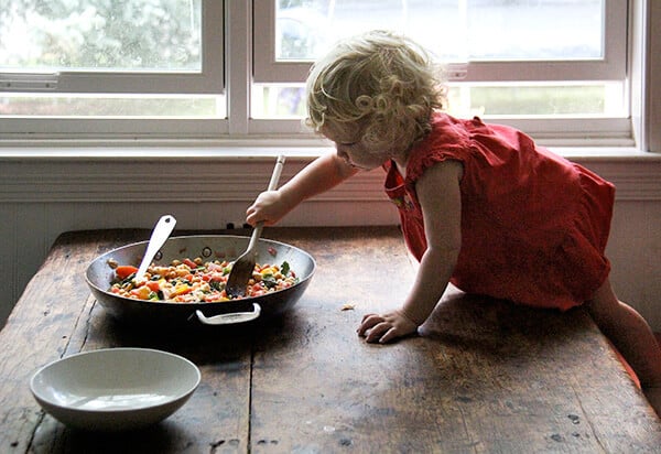 Tig在桌子上搅拌炖鹰嘴豆。