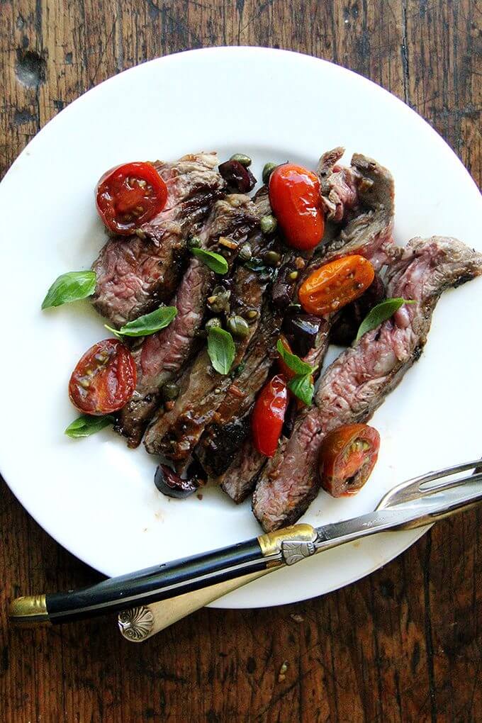 In this skirt steak nicoise, while the skirt steak rests, you’ll make a simple sauce Niçoise. After halving cherry tomatoes, coarsely chopping olives, and tossing the two with capers, you’ll briefly sauté the mix with olive oil and garlic. After just a few minutes, the tomatoes will begin to break down, releasing juices and sweetening as they soften. A squeeze of fresh lemon juice at the end offers a welcomed hit of acidity. // www.simonrockett.com 这件裙子牛排尼斯,而裙子牛排休息,你会做一个简单的酱尼斯。樱桃番茄减半后,粗切橄榄,扔两个酸豆,你会短暂地炒混合橄榄油和大蒜。几分钟后,番茄会开始分解,释放出果汁和脱硫软化。鲜榨柠檬汁在最后提供了一个欢迎的酸度。/ / www.simonrockett.com