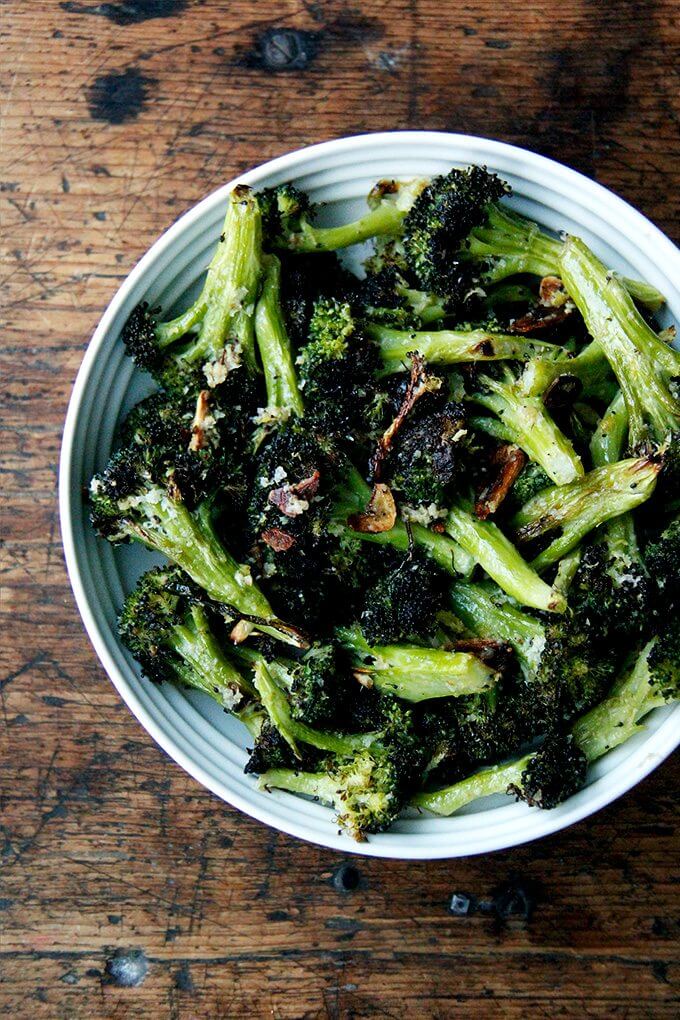 This roasted broccoli recipe is excellent and easy. I've made it three times in my portable Waring oven on two mini sheet pans in the past week because it just tastes so darn good right now—it's just what I'm craving after many weeks of indulging. // www.simonrockett.com 加藤一碗艾娜的烤西兰花用大蒜、柠檬、和帕尔玛。