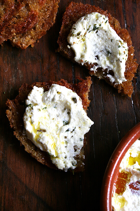 Fresh ricotta pairs so well with grilled bread -- there's something about the combination of cool and creamy with smoky and charred. These little embellishments go a long way, and if you've never tried any of them or haven't yet tried making homemade ricotta, try it now. // www.simonrockett.com 片烤面包,加上意大利乳清干酪和草药。