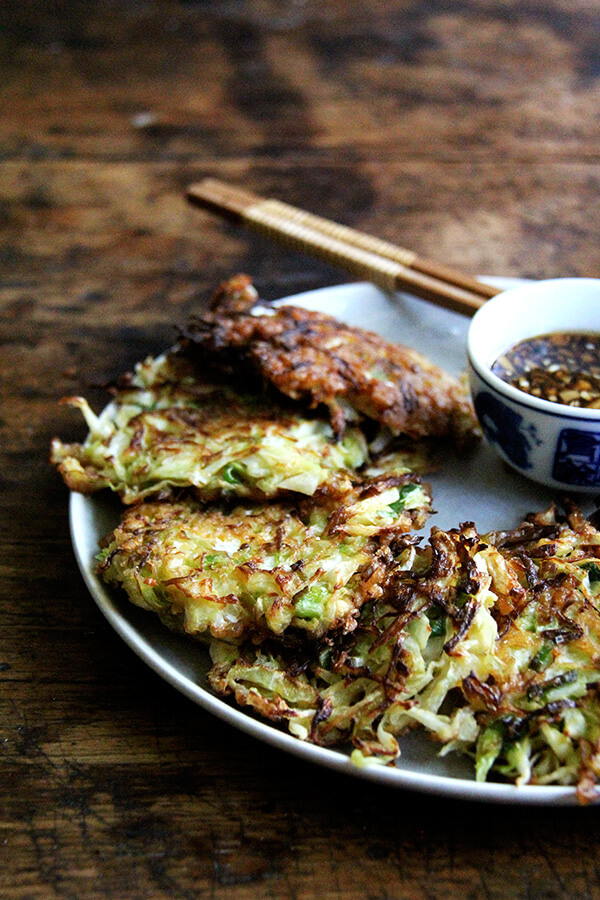 Okonomiyaki, Japanese cabbage pancakes, can be made in countless ways: okonomiyaki essentially means prepared as you like. This my favorite version I've made yet, but know that you can add to it as you like with shrimp or chicken, sesame seeds or bonito flakes, other vegetables, etc. I prefer a soy-based dipping sauce to the more traditional mayonnaise-based, and, like the corn fritters, find these as irresistible freshly fried as cold straight from the fridge. // www.simonrockett.com 御好烧的盘。
