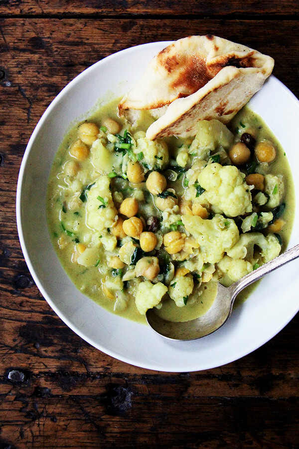 These curried chickpeas come together quickly if you have the chickpeas cooked ahead of time: sauté aromatics, add cooked legume or uncooked lentil (or quick-cooking grain), simmer everything in a mix of coconut milk and water. It's simple and delicious. Healthy, too. // www.simonrockett.com 一碗咖喱鹰嘴豆和花椰菜。