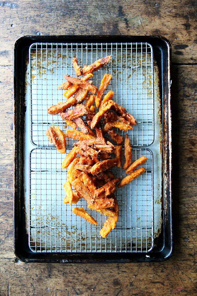 If anything deters you from making these thick-cut sweet potato fries, let it be time, not fear — of fat or the frying process — because these fries, if anything, are less greasy than roasted sweet potatoes wedges, and they are completely irresistible. // www.simonrockett.com 一盘油炸甘薯厚切薯条。