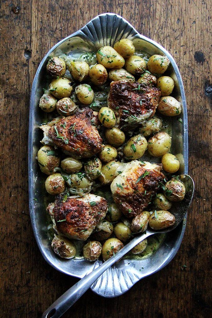 With five minutes of prep you can have this one-pan chicken with potatoes and tarragon ready for the oven, and the result—incredibly juicy, evenly browned chicken plus well-seasoned potatoes showered with tarragon—will have you marveling. This dish is a small miracle. // www.simonrockett.com 一个充满“盘烤鸡大腿和土豆。