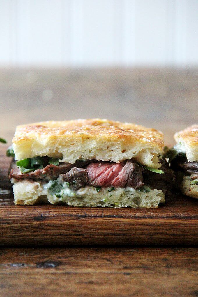In these skirt steak sandwiches, skirt steak, which cooks to medium-rare in just about 5 minutes, is layered with arugula between slices of focaccia smeared with herbed mayonnaise. The key, as with all meats, is to let the steak rest for at least 10 minutes before slicing, and with skirt steak, to slice it thinly against the grain. // www.simonrockett.com 在这些裙子牛排三明治,裙子牛排,厨师在大约5分钟,三分熟是分层与芝麻菜片佛卡夏之间抹香草蛋黄酱。正如所有肉类,关键是让牛排切前休息至少10分钟,和裙子的牛排,片薄格格不入。/ / www.simonrockett.com