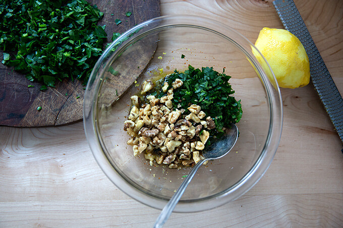 搅拌在一起walnut-caper莎莎在一个小玻璃碗