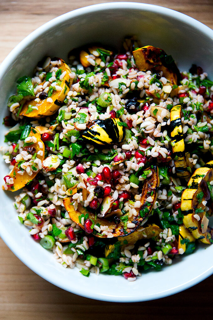 白色的塔博勒色拉碗冬天和烤的红薯南瓜片。