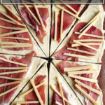 羊角面包面团、滚切成三角形,顶部有火腿和奶酪