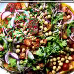 一盘以色列香料番茄鹰嘴豆沙拉配黄瓜酸奶酱。