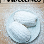 柠檬玛德琳蛋糕上撒上糖粉，放在冷却架上。