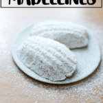 柠檬玛德琳蛋糕上撒上糖粉，放在冷却架上。