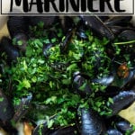 A pot of mussels showered in parsley.