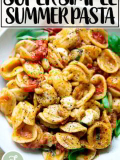 一碗意大利面拌上樱桃番茄沙司、松子、罗勒和马苏里拉奶酪。