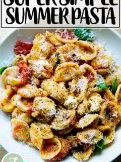 一碗意大利面拌上樱桃番茄沙司、松子、罗勒和马苏里拉奶酪。