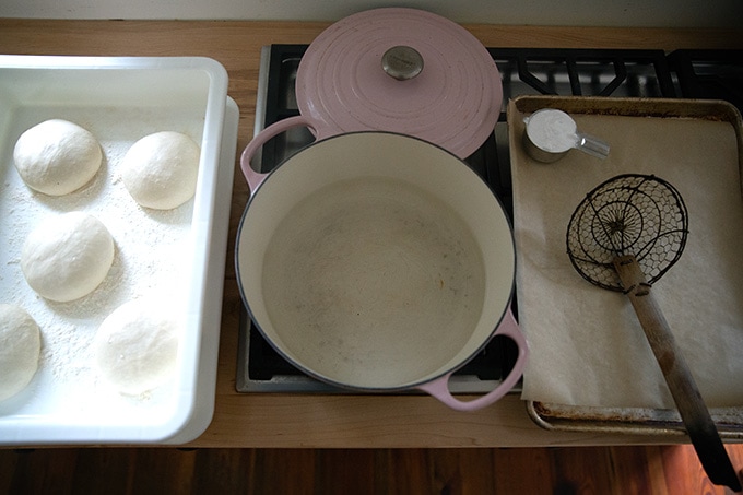 一壶水在炉子上一边上升椒盐卷饼面团滚球和一个平底锅。