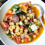 一碗stewy鹰嘴豆番茄和罗勒。