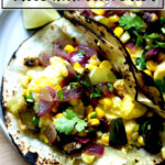 鸡蛋炸玉米饼withBreakfast炸玉米饼Caramelo玉米饼和烤玉米和波布拉诺椒莎莎呈深绿色。