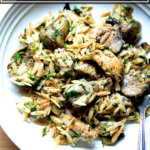 开销的白色板与柠檬、米粒、鸡肉和洋蓟心。