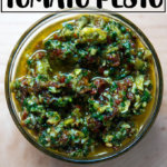 一个架空的一碗拿着太阳dried-tomato香蒜酱。