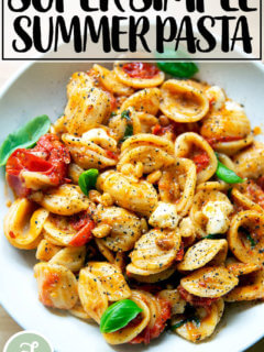 一碗意大利面拌上樱桃番茄沙司、松子、罗勒和马苏里拉奶酪。