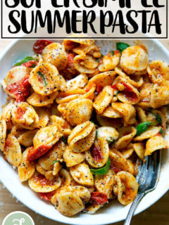 一碗意大利面拌上樱桃番茄沙司、松子、罗勒和马苏里拉奶酪。