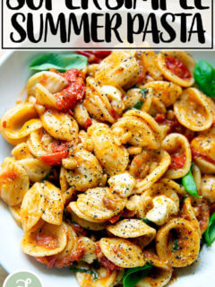 一碗意大利面拌上樱桃番茄沙司、松子、罗勒和马苏里拉奶酪。