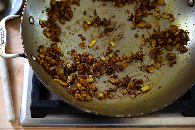 加热的锅炒洋葱,大蒜,生姜,咖喱香料。